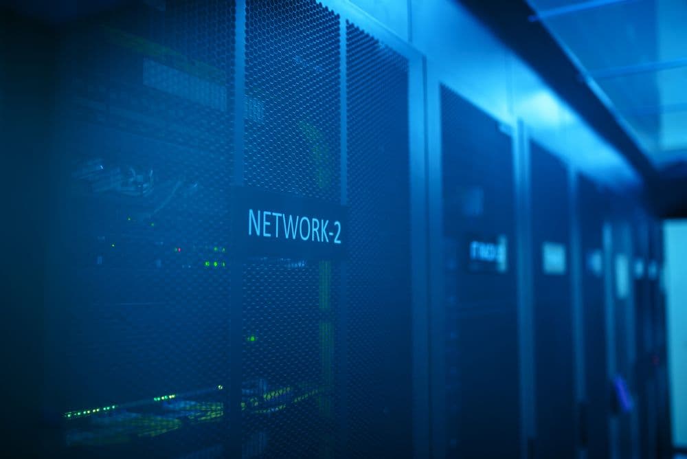 Network equipment racks lit in blue inside a server room